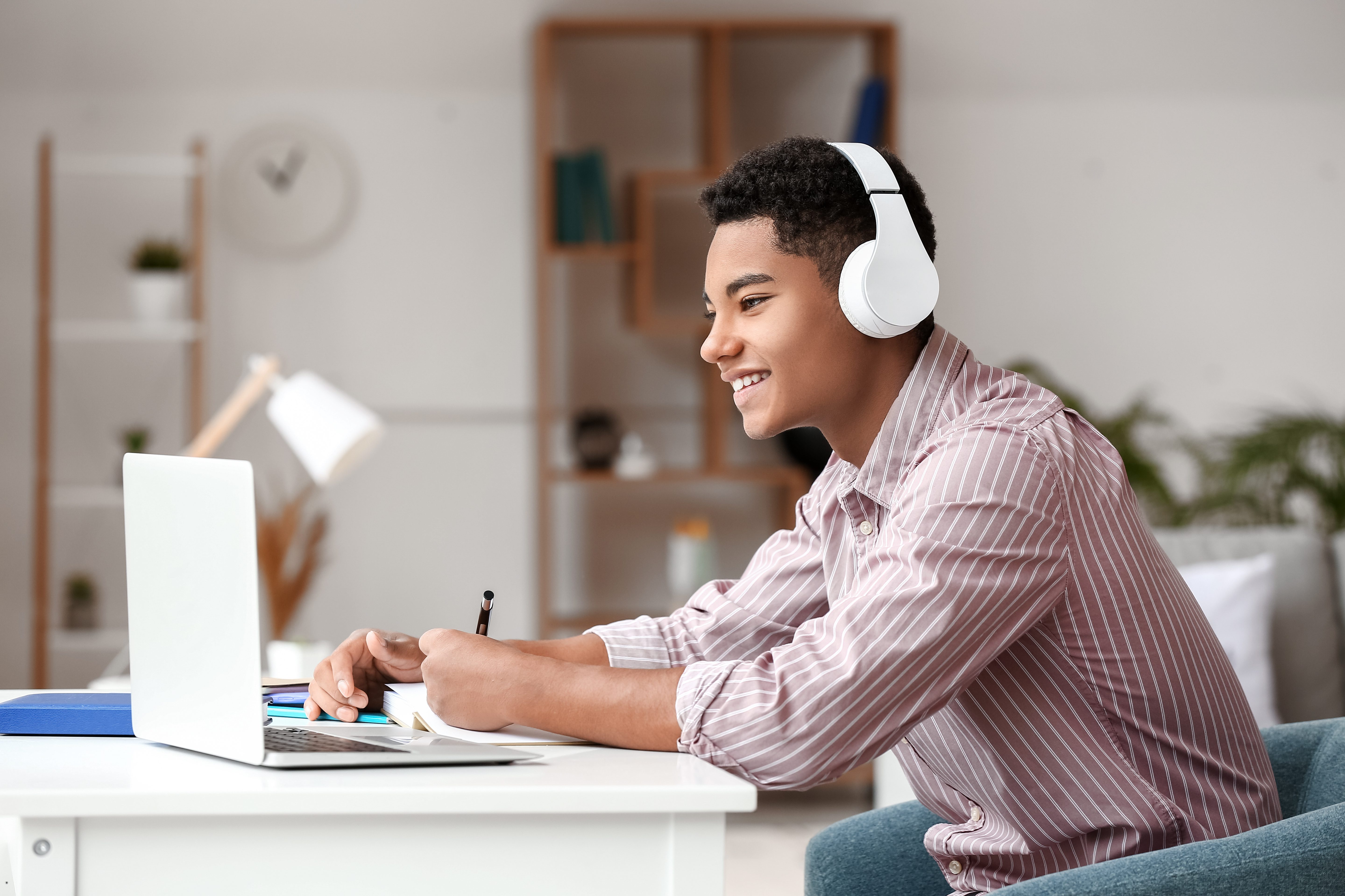 online high school. African-American student studying online at home